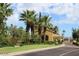 Picturesque entry with palm trees, landscaping, and a charming guardhouse leading to the community at 23123 N Cardenas Dr, Sun City West, AZ 85375