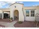 Inviting covered front porch with tiled walkway, desert landscaping, and a charming sitting area at 23123 N Cardenas Dr, Sun City West, AZ 85375