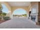 Inviting outdoor lounge featuring an arched entrance, fireplace, and serene views of manicured landscapes at 23123 N Cardenas Dr, Sun City West, AZ 85375