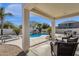 Inviting back patio area with wicker furniture overlooks a refreshing pool and landscaped yard at 2417 W Apache Rain Rd, Phoenix, AZ 85085