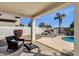 Cozy covered back patio seating area offers a relaxing view of the private pool and garden at 2417 W Apache Rain Rd, Phoenix, AZ 85085