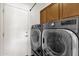 Well-equipped laundry room with front-load washer and dryer and ample storage at 2417 W Apache Rain Rd, Phoenix, AZ 85085