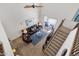 A view of the living room features a ceiling fan, staircase and leather furniture at 2417 W Apache Rain Rd, Phoenix, AZ 85085