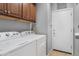 This laundry room features a Whirlpool washer and dryer set and plenty of cabinet space above at 2512 E Vermont Dr, Gilbert, AZ 85295