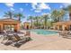 Community pool with lounge chairs, covered seating areas, and palm trees surrounding at 2512 E Vermont Dr, Gilbert, AZ 85295