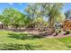 Beautifully landscaped front yard with lush green grass, shrubs, and mature trees at 2512 E Vermont Dr, Gilbert, AZ 85295