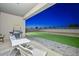 Covered patio with a barbecue grill, a table and chairs overlooking the backyard with artificial grass at 30116 W Fairmount Ave, Buckeye, AZ 85396