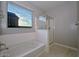 Bright bathroom with tiled floors, a soaking tub, and a shower at 30116 W Fairmount Ave, Buckeye, AZ 85396