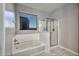 Bright bathroom featuring a soaking tub, a glass-enclosed shower, and a window at 30116 W Fairmount Ave, Buckeye, AZ 85396