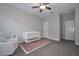 Well-lit Bedroom featuring neutral walls, carpet flooring, and a crib and chair at 30116 W Fairmount Ave, Buckeye, AZ 85396