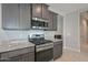 Modern kitchen showcasing a stainless steel gas range, granite counters, and dark cabinets at 30116 W Fairmount Ave, Buckeye, AZ 85396