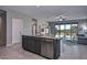 Modern kitchen featuring an island with seating, a view to the living room and outdoor access at 30116 W Fairmount Ave, Buckeye, AZ 85396