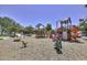 A colorful community playground with slides, climbing structures, and spring riders on a wood chip surface at 30116 W Fairmount Ave, Buckeye, AZ 85396