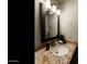 Close up of bathroom vanity with granite countertop, a decorative mirror, and modern light fixture at 322 W Laguna Dr, Tempe, AZ 85282