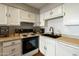 Bright kitchen featuring white cabinets, updated appliances, and a sleek black sink at 322 W Laguna Dr, Tempe, AZ 85282