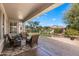 Covered back patio featuring brick pavers, comfortable wicker furniture, and an inviting view of the home's backyard at 4542 E Carob Dr, Gilbert, AZ 85298