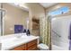 Bathroom featuring a vanity with a sink, a framed mirror, and a shower-tub combo with a decorative shower curtain at 4542 E Carob Dr, Gilbert, AZ 85298