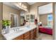 Bathroom with double sink vanity, mirrors, decorative plants, and access to the bright and inviting main bedroom at 4542 E Carob Dr, Gilbert, AZ 85298