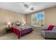 Comfortable bedroom featuring a ceiling fan, large window with shutters, and a cozy seating area at 4542 E Carob Dr, Gilbert, AZ 85298