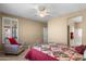 Inviting bedroom with a ceiling fan, plantation shutters, and a comfortable accent chair at 4542 E Carob Dr, Gilbert, AZ 85298