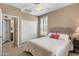 Bedroom boasting carpet floors, ceiling fan, plantation shutters, and a view to the en-suite bathroom at 4542 E Carob Dr, Gilbert, AZ 85298