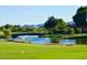 Scenic view of the Trilogy Golf Course at Power Ranch with lush fairways, a pond, and mountain backdrop at 4542 E Carob Dr, Gilbert, AZ 85298