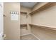 Organized walk-in closet with multiple shelves, hanging rods, and neutral-colored walls at 4542 E Carob Dr, Gilbert, AZ 85298