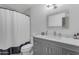 Modern bathroom with a gray vanity, chrome fixtures, decorative mirror and neutral-toned shower curtain at 5165 E Tunder Dr, Phoenix, AZ 85044