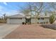 Inviting single-story home featuring desert landscaping with flowers and an attached two-car garage at 5165 E Tunder Dr, Phoenix, AZ 85044