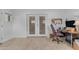 Well-lit home office area with wood look tile floors, desk, and plenty of natural light from patio doors at 5165 E Tunder Dr, Phoenix, AZ 85044