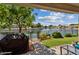 Back patio with outdoor grill, manicured landscaping, and lake views at 5471 W Quail Ave, Glendale, AZ 85308