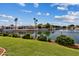 Backyard featuring lush landscaping, green grass, and waterfront view at 5471 W Quail Ave, Glendale, AZ 85308