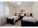 Bedroom with twin beds, a ceiling fan, a decorative metal tree on the wall, and a large window at 5471 W Quail Ave, Glendale, AZ 85308