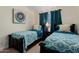 Bedroom featuring two twin beds with patterned comforters, a ceiling fan, and a small nightstand at 5471 W Quail Ave, Glendale, AZ 85308