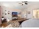 Bright bedroom featuring hardwood floors, a ceiling fan, and a view of the staircase through an open doorway at 5471 W Quail Ave, Glendale, AZ 85308