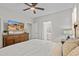 Spacious bedroom with a ceiling fan, dresser with television, and a view into the bathroom at 5644 N 206Th Gln, Buckeye, AZ 85396