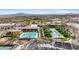 Aerial view of community featuring pools, spacious clubhouse, palm trees, and ample parking at 5644 N 206Th Gln, Buckeye, AZ 85396