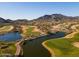 Scenic aerial view of a golf course with lush green fairways, water features, and mountain backdrop at 5644 N 206Th Gln, Buckeye, AZ 85396