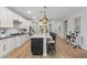 Kitchen featuring an island with white countertops and black cabinets, stainless steel appliances and wood floors at 5644 N 206Th Gln, Buckeye, AZ 85396