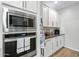 Modern kitchen featuring stainless steel microwave and oven appliances with white shaker cabinets and an apron hanging from the cabinet at 5644 N 206Th Gln, Buckeye, AZ 85396