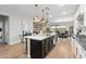 Gourmet kitchen island with stainless steel sink and white countertops with pendant lighting and wood floors at 5644 N 206Th Gln, Buckeye, AZ 85396