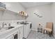 Functional laundry room with a sink, shelving for storage, and modern washer and dryer units at 5644 N 206Th Gln, Buckeye, AZ 85396