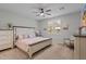 Cozy main bedroom with neutral walls, carpet flooring, stylish furniture, ceiling fan and a window with plantation shutters at 5644 N 206Th Gln, Buckeye, AZ 85396