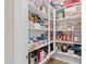 Walk-in pantry featuring an abundance of organized food and cooking supplies on white shelves with vinyl floors at 5644 N 206Th Gln, Buckeye, AZ 85396