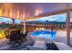 Patio seating area with a view of the pool and outdoor lighting for evening relaxation at 5644 N 206Th Gln, Buckeye, AZ 85396