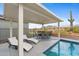 Relaxing poolside patio with lounge chairs, dining area, and a beautiful desert view at 5644 N 206Th Gln, Buckeye, AZ 85396