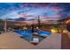 Backyard pool and spa with lights, lounge chairs, and scenic desert views at dusk at 5644 N 206Th Gln, Buckeye, AZ 85396