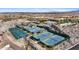 Overhead view of well-maintained tennis and pickleball courts surrounded by desert landscaping and community buildings at 5644 N 206Th Gln, Buckeye, AZ 85396