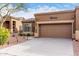 Lovely home featuring a two-car garage and a desert-style landscape with native plants at 7195 E Canyon Wren Dr, Gold Canyon, AZ 85118