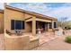 Covered patio featuring an outdoor kitchen and dining set on a textured patio at 7195 E Canyon Wren Dr, Gold Canyon, AZ 85118